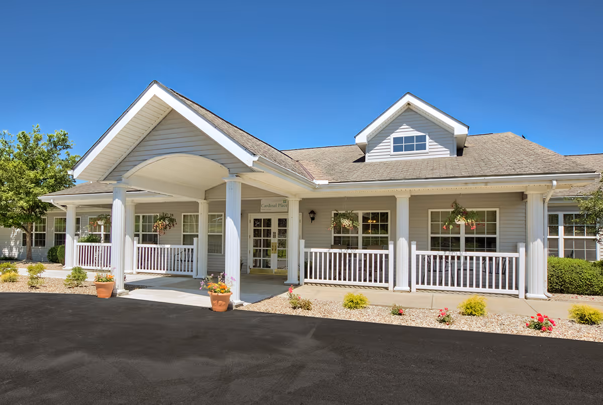 Front view of a senior living facility with white columns and a covered entrance.
