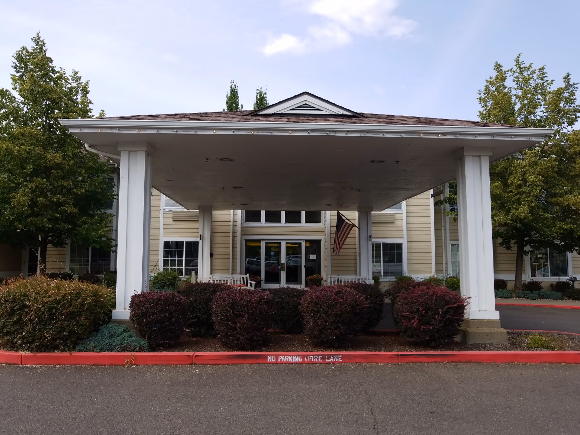 Brookdale Geary Street facility entrance with a covered driveway and manicured shrubs