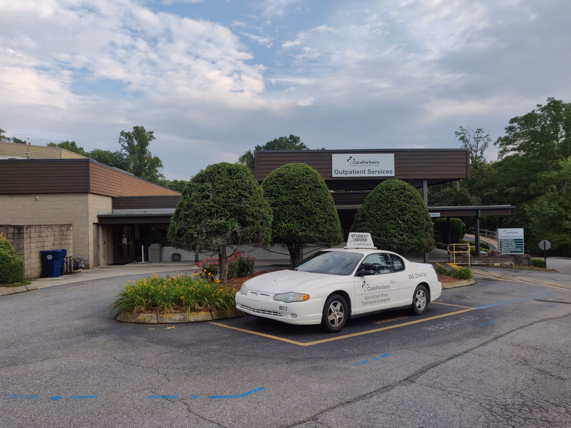 Exterior view of Care Partners Outpatient Services with a white car in the parking lot