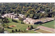 Aerial view of a senior living campus with several buildings and surrounding lawns.