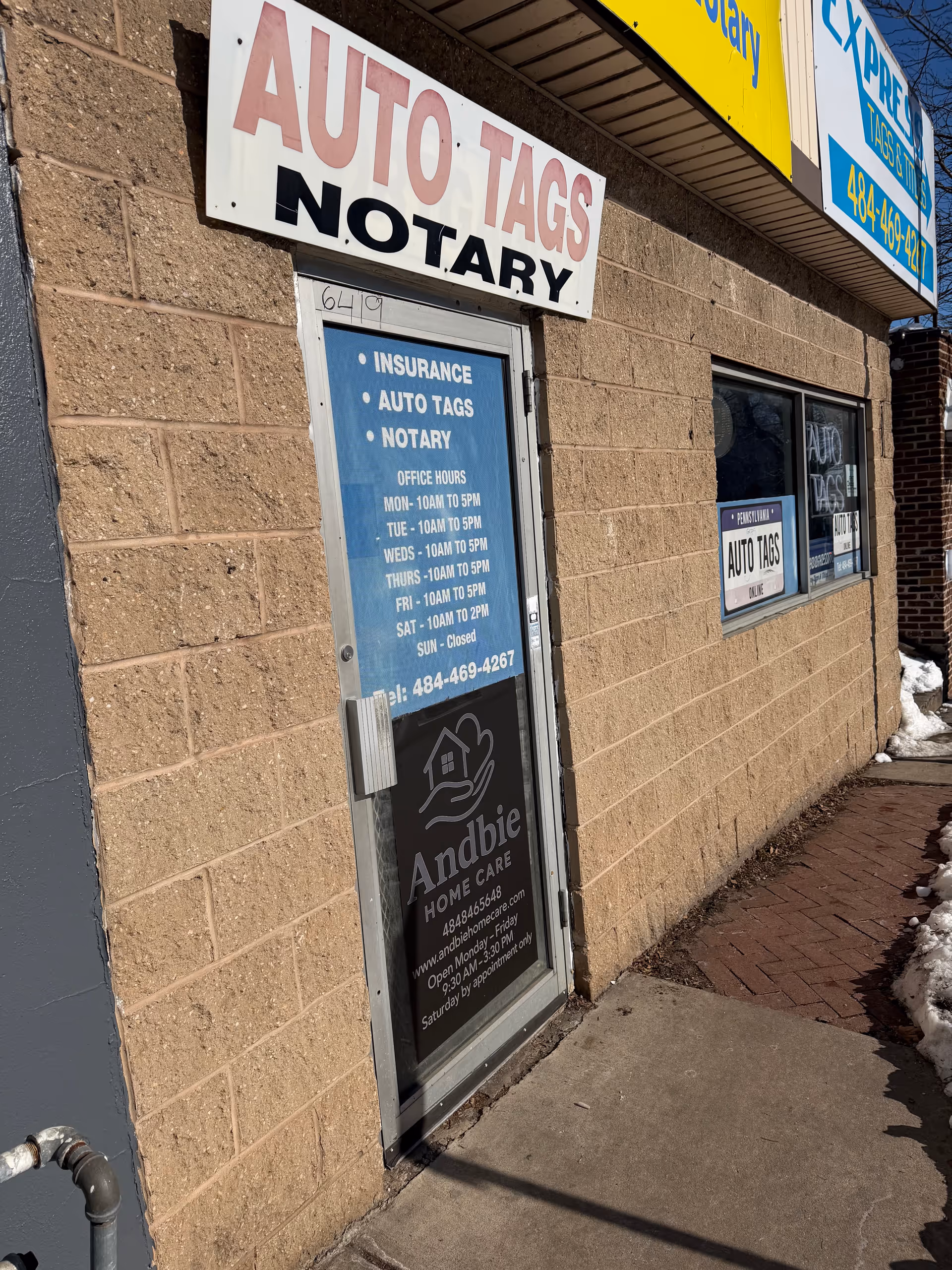 Brick storefront with large Auto Tags Notary sign and Andbie Home Care door