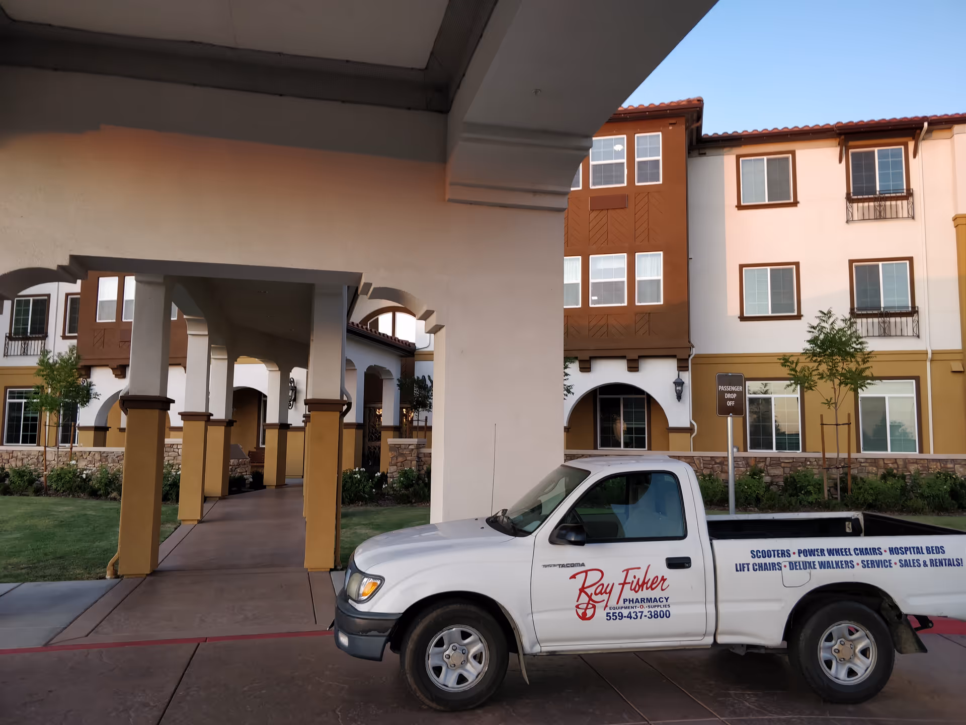 Exterior view of The Vineyards retirement community with a parked Ray Fisher Pharmacy truck.