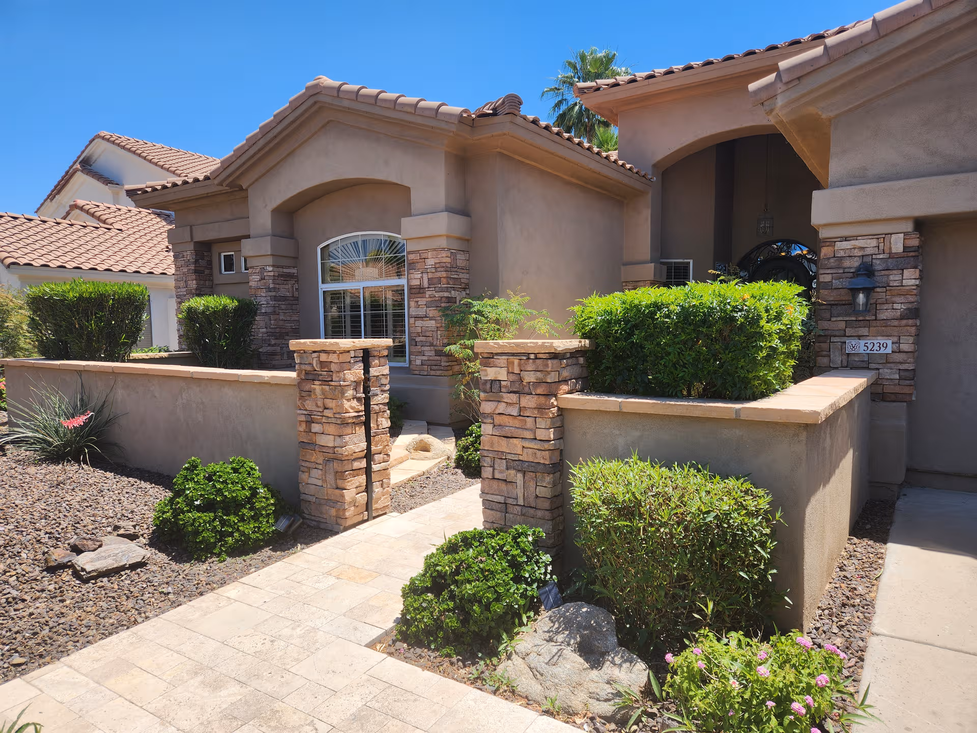 Hummingbird Retreat front exterior: beige building with stone pillars and landscaped entry.