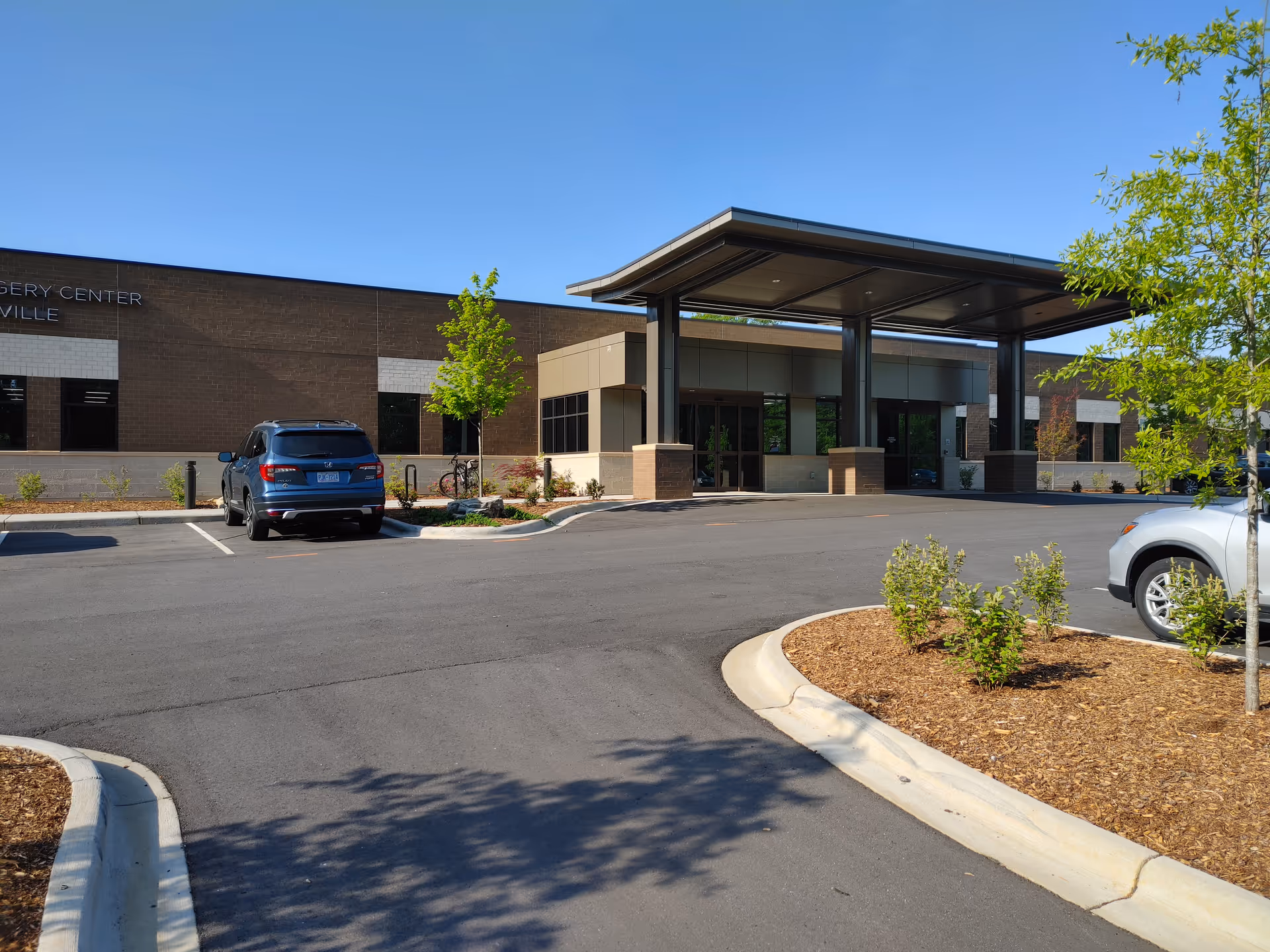 Front exterior of Outpatient Surgery Center of Asheville with canopy entrance and parking.