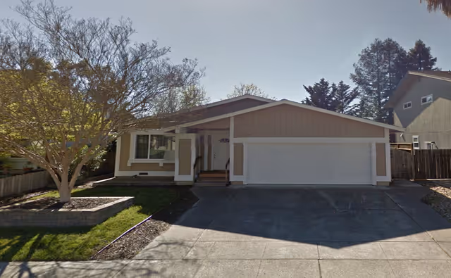 Sunset Garden II facility exterior: a single-story house with a two-car garage and front yard.
