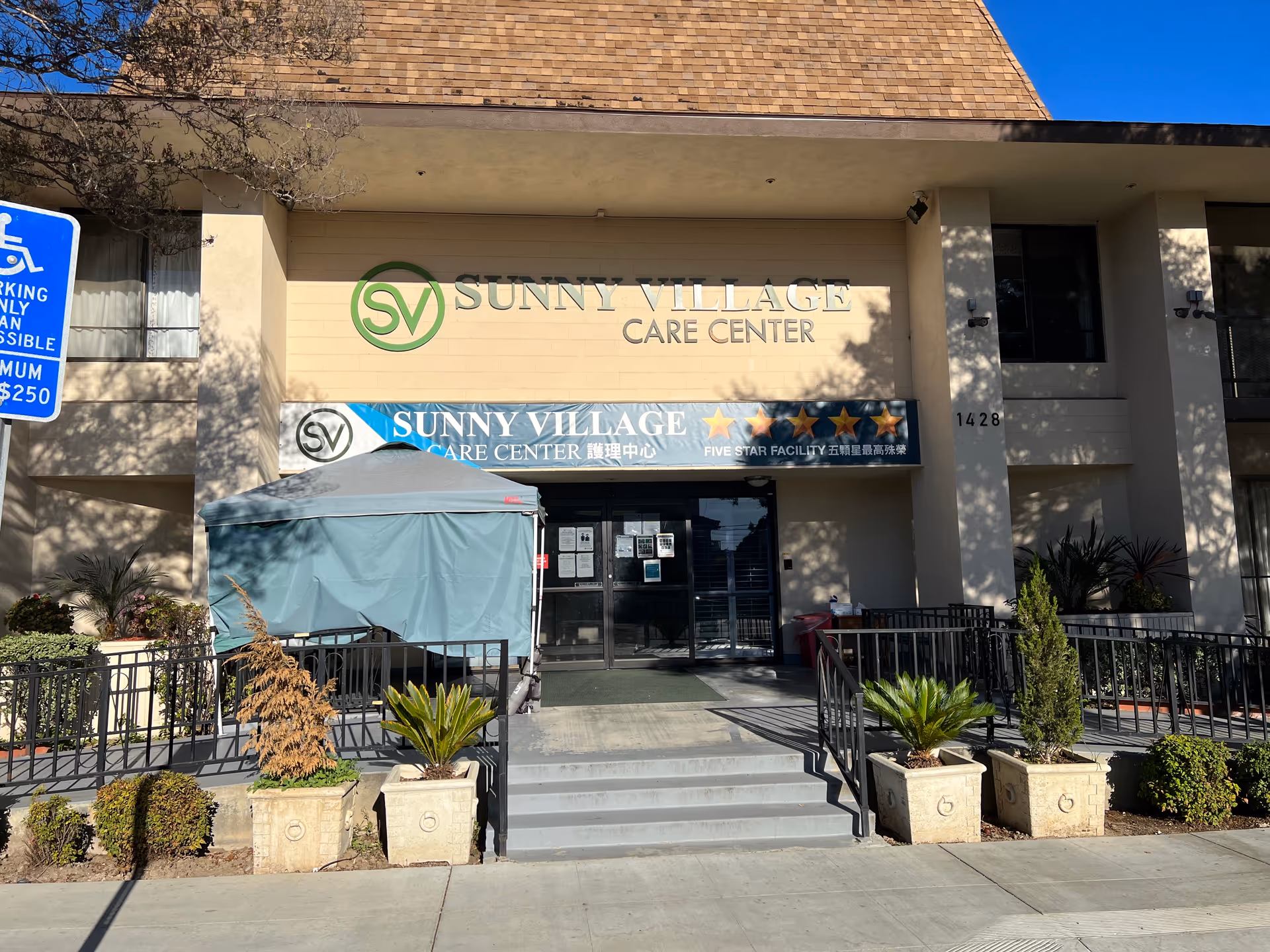 Sunny Village Care Center storefront with entrance, canopy, planters, and accessible parking sign.