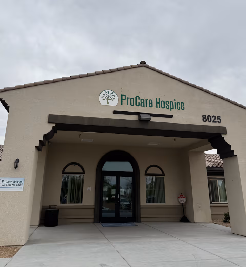 Front view of a beige hospice building with ProCare Hospice sign and entrance.