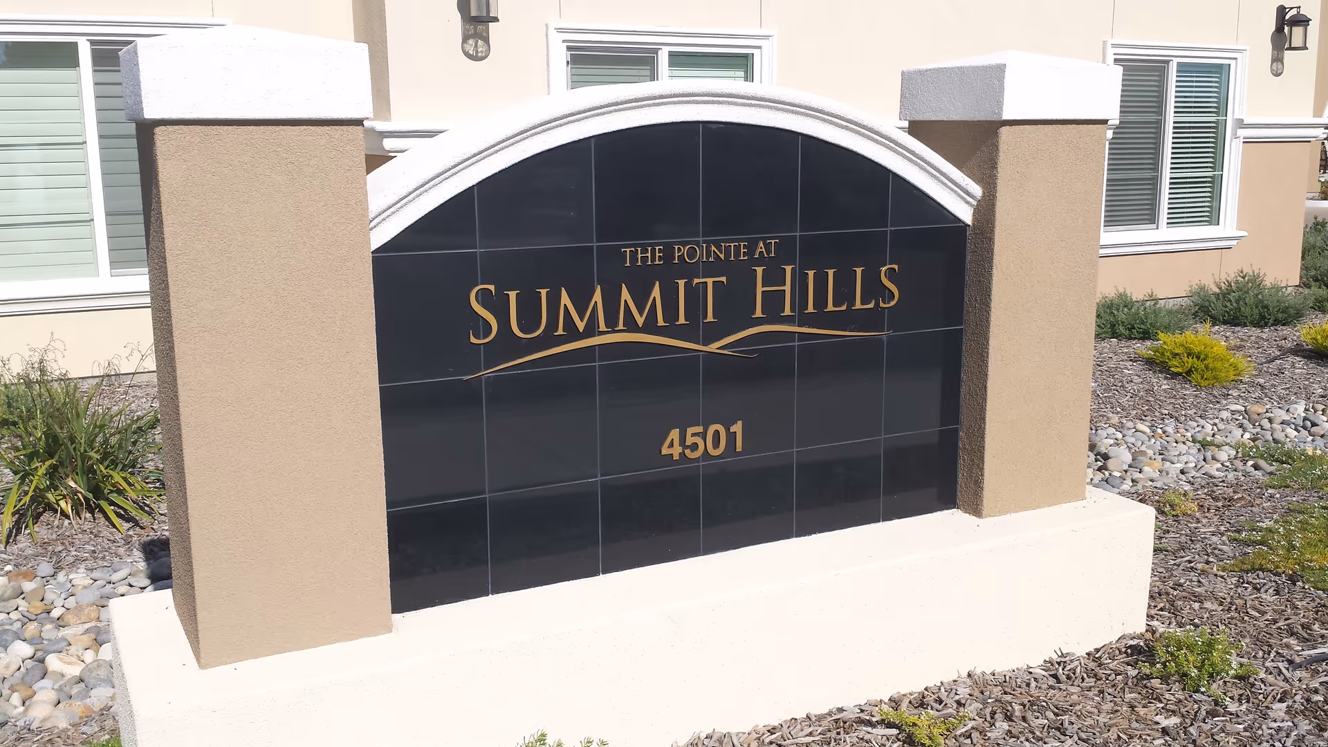 Front entrance sign reads The Pointe at Summit Hills with landscaping and building in background.