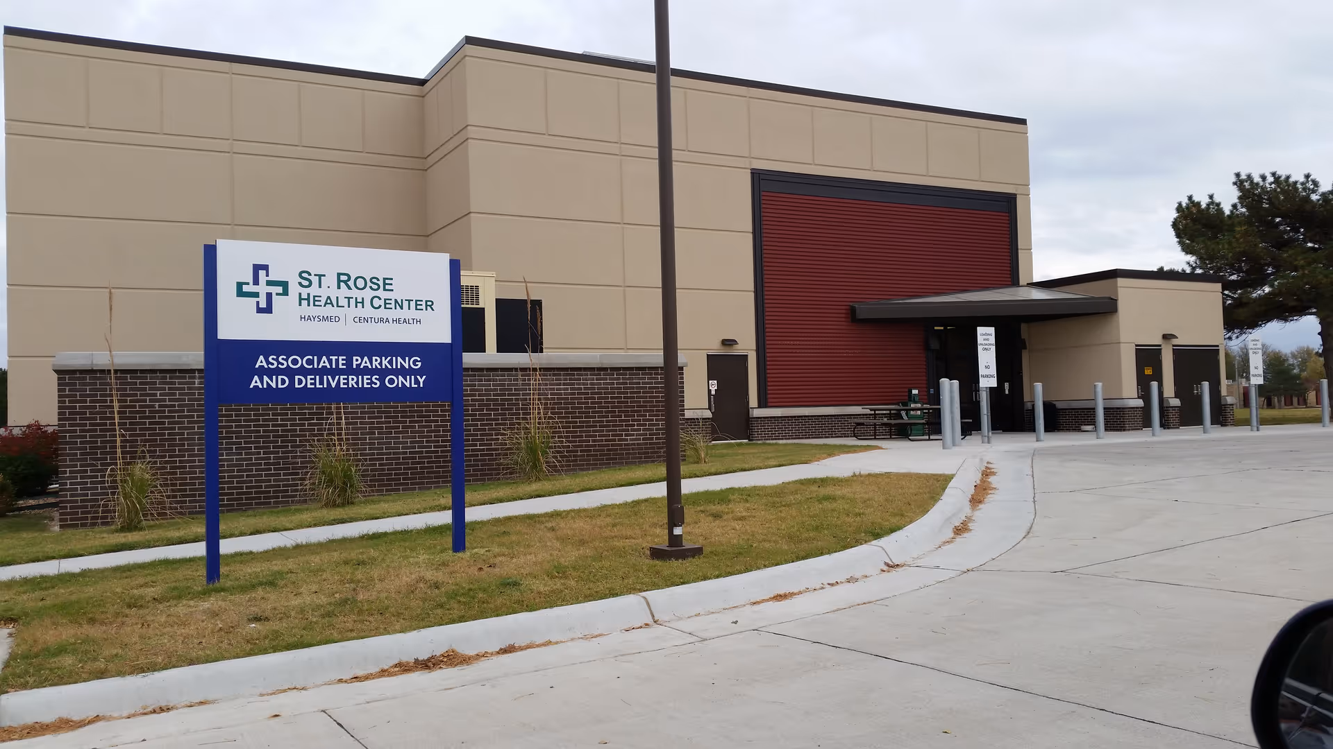 Exterior view of St. Rose Health Center building with sign, driveway, and entrance.