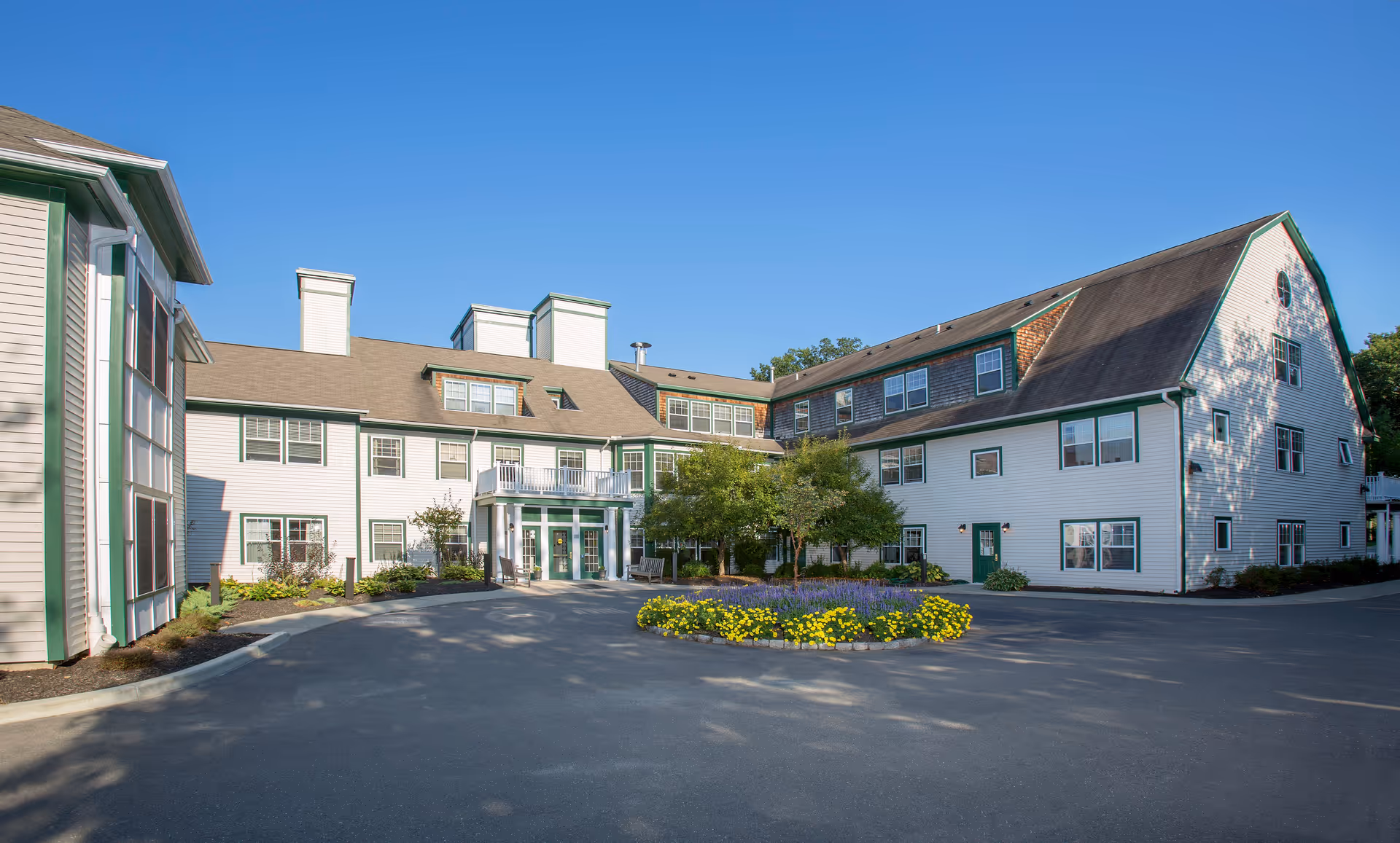 Exterior view of Crescent Point at Niantic buildings with a circular driveway and landscaped center island.