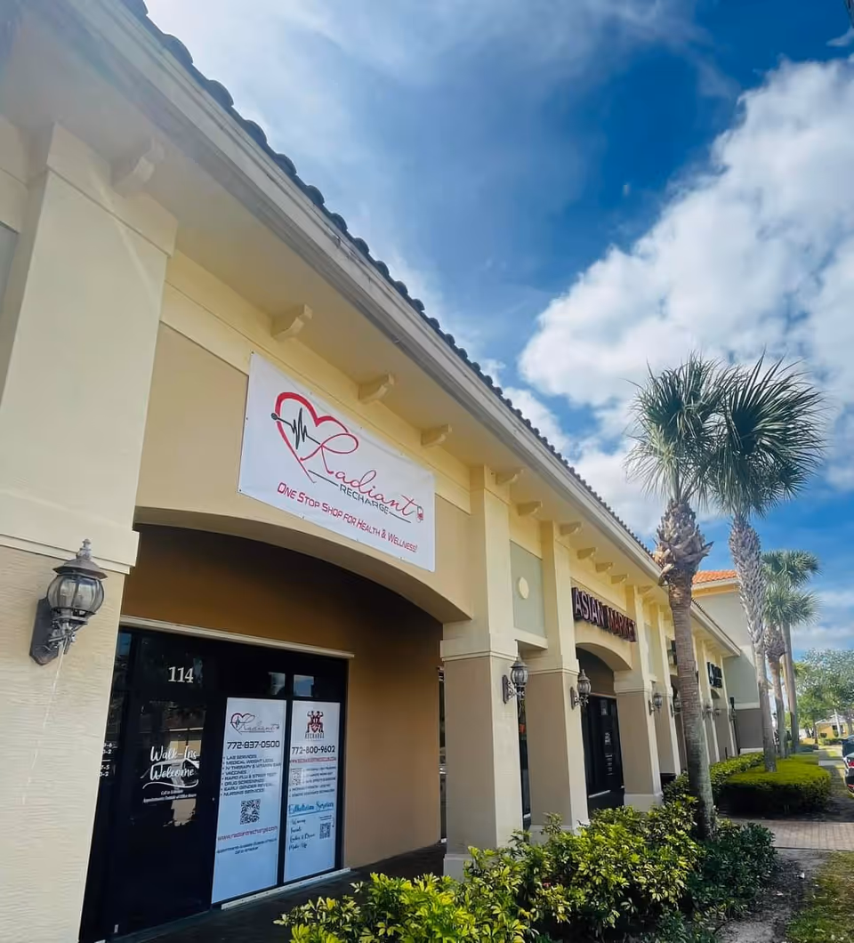 Exterior view of a senior living center storefront with palm trees and Radiant Recharge signage