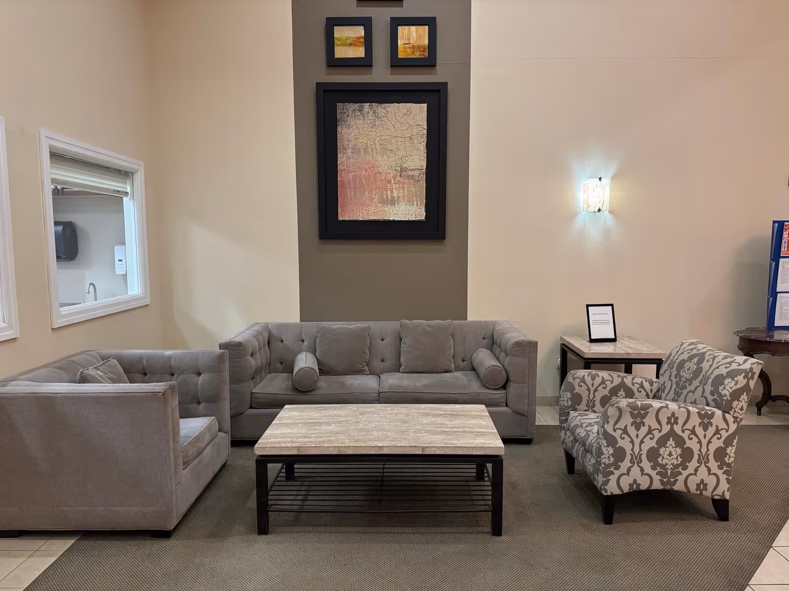 Gray sofas and patterned chairs in a modern senior living lounge.