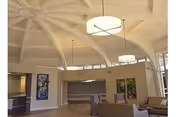 Bright, airy lobby with curved architecture, seating, and large windows in a nursing facility.