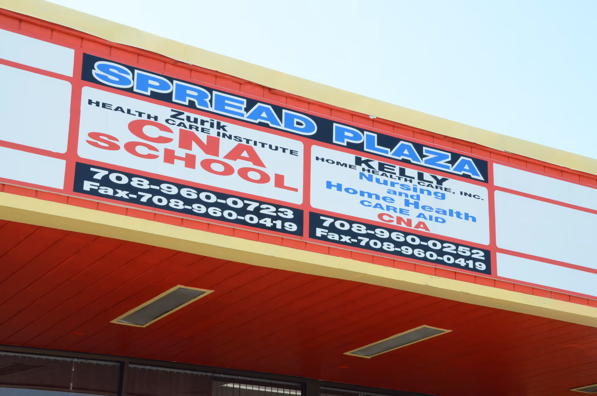 Exterior building facade with a large sign advertising Spread Plaza and Zurik Healthcare Institute.