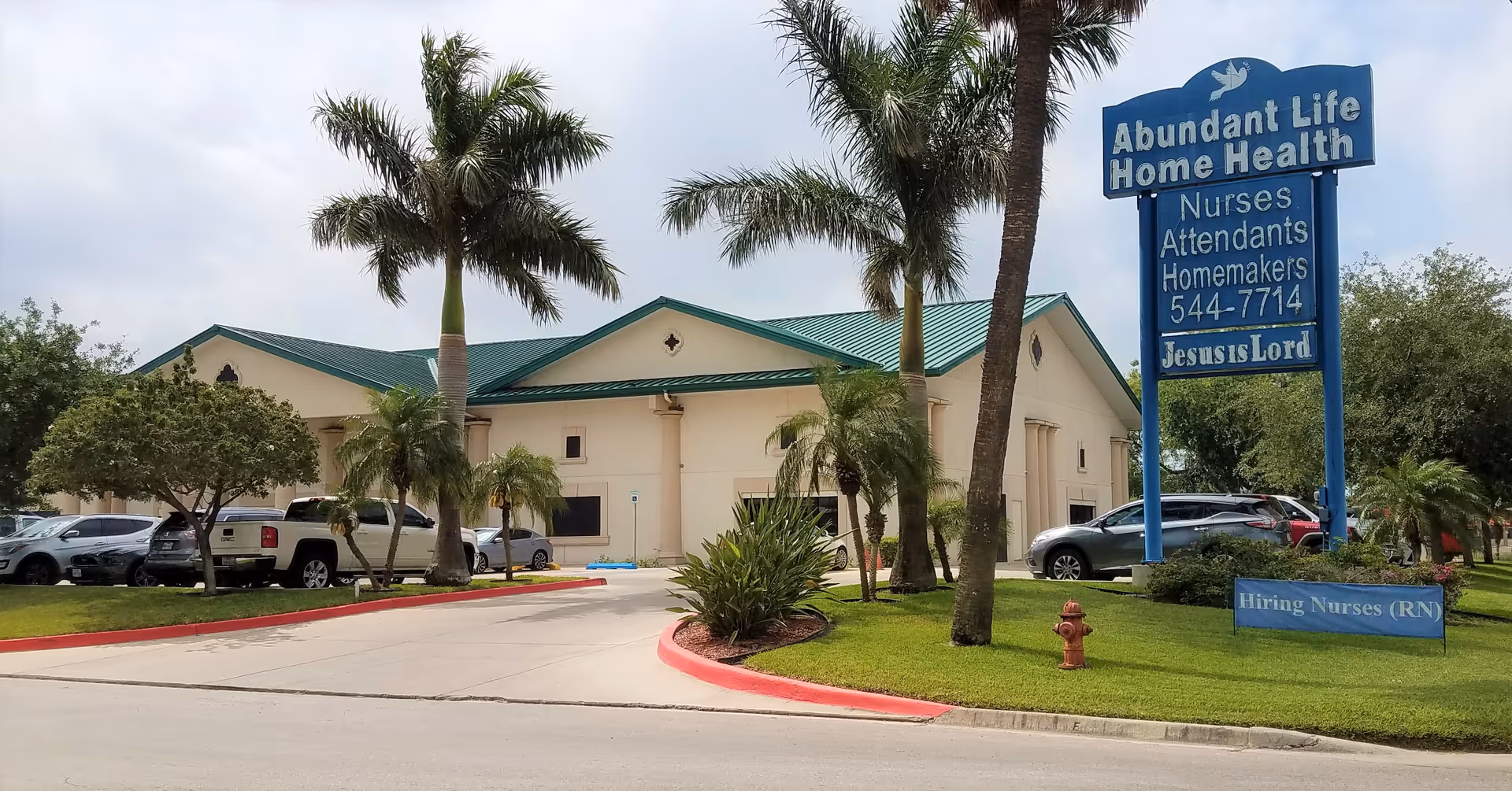 Exterior view of Abundant Life Home Health facility with palm trees and blue sign