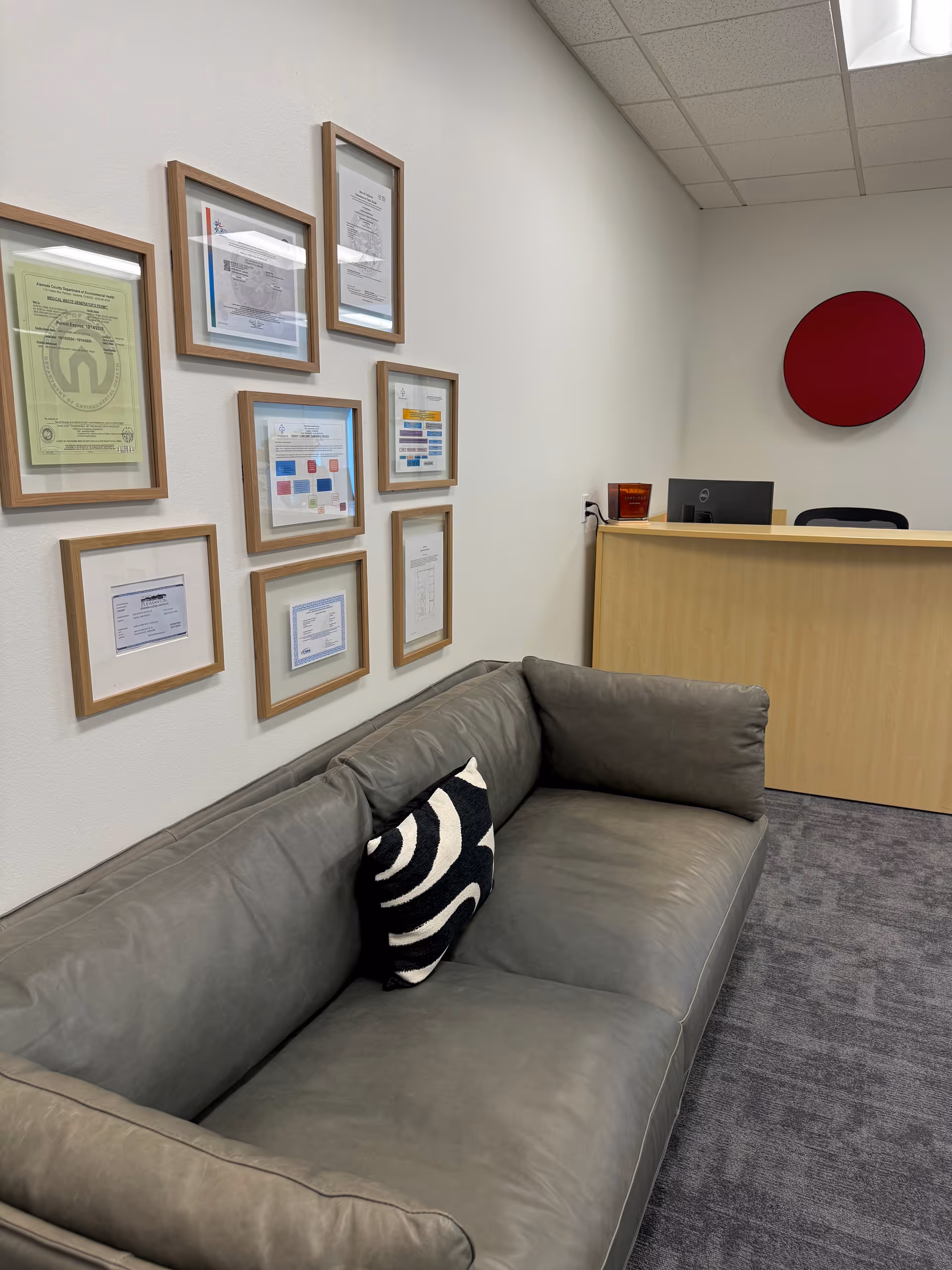 NorCal Home Health Services waiting area with a gray sofa, framed certificates, and a reception desk.
