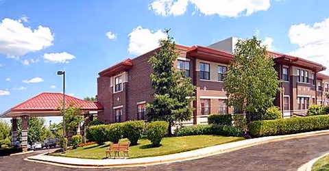 Exterior view of Alden of Waterford senior living facility with brick walls and landscaping.