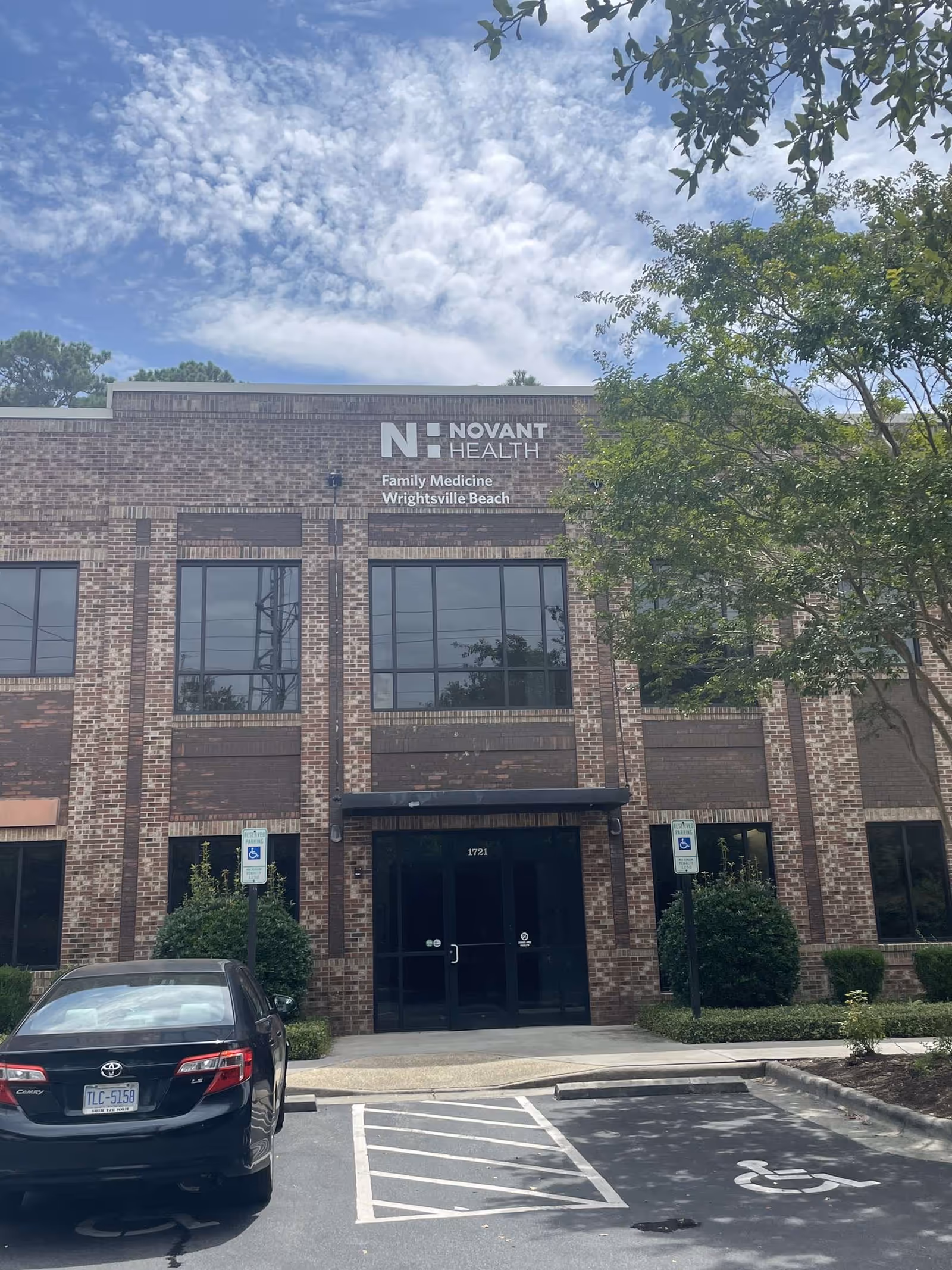 A brick medical building facade displays a Novant Health sign with large windows.