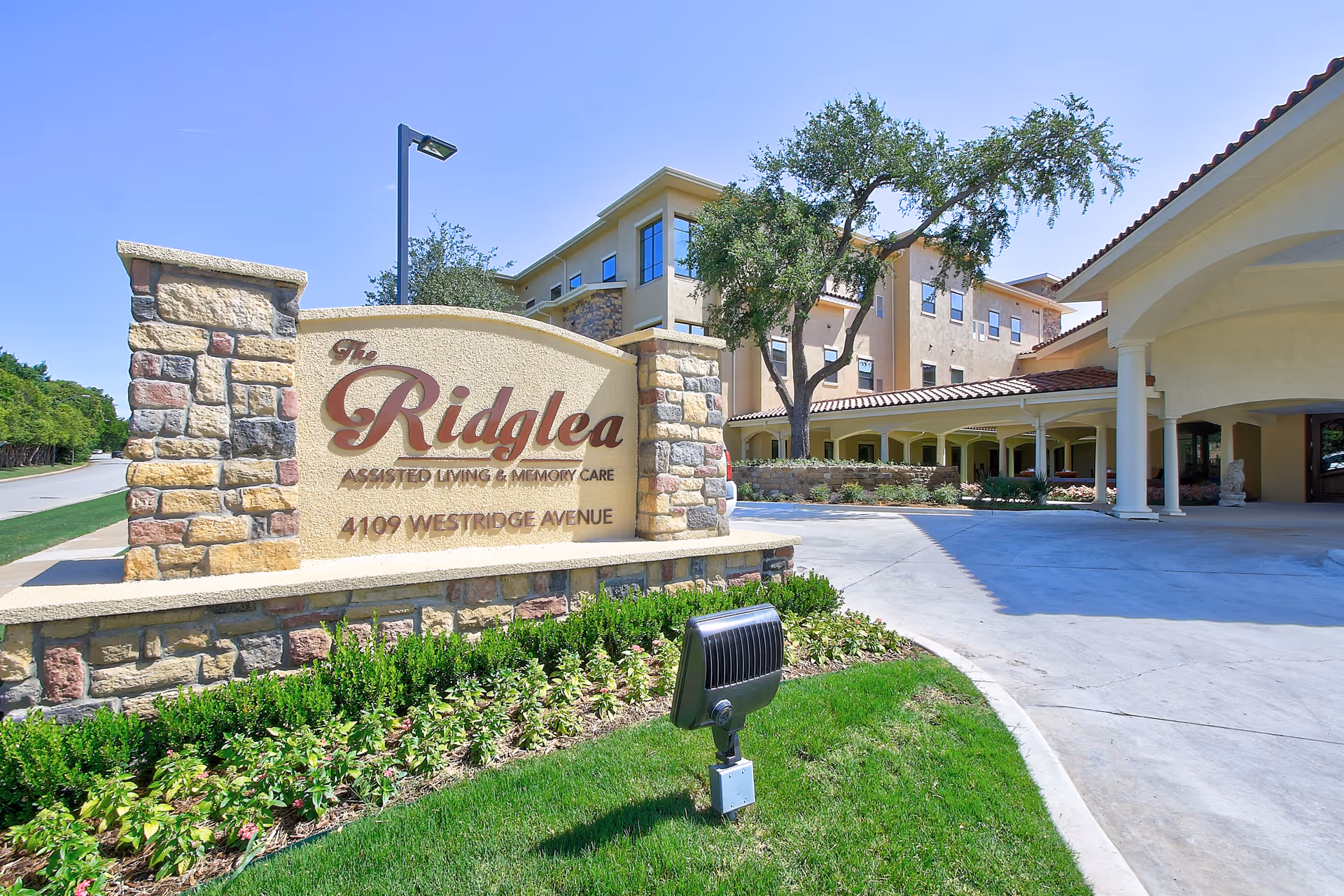 The Ridglea Senior Living exterior with stone sign and covered entrance.