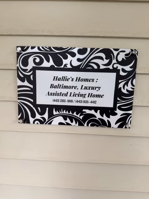 Exterior beige siding with a decorative sign for Hallie's Homes Baltimore, Luxury Assisted Living.