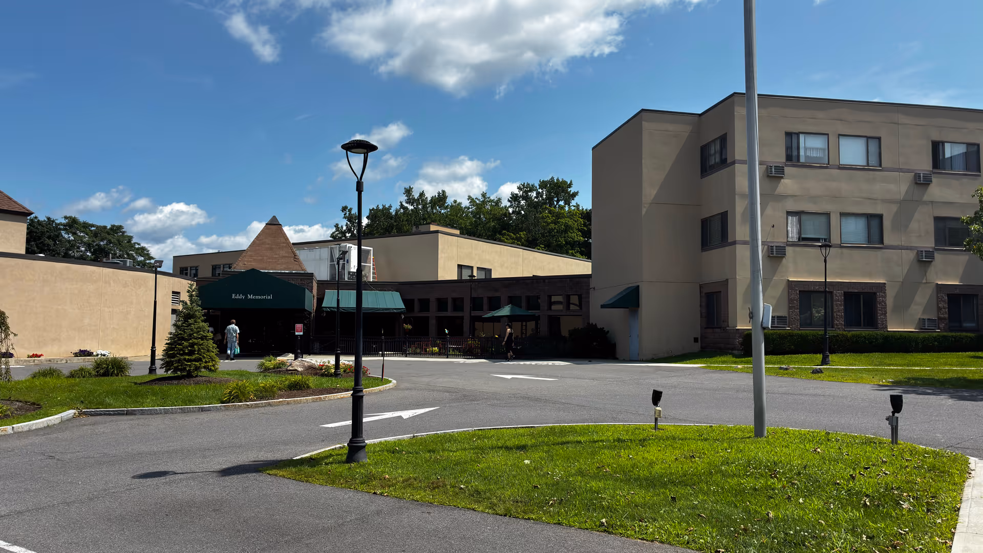 Exterior view of Terrace at Eddy Memorial senior living facility with entrance and green awning.
