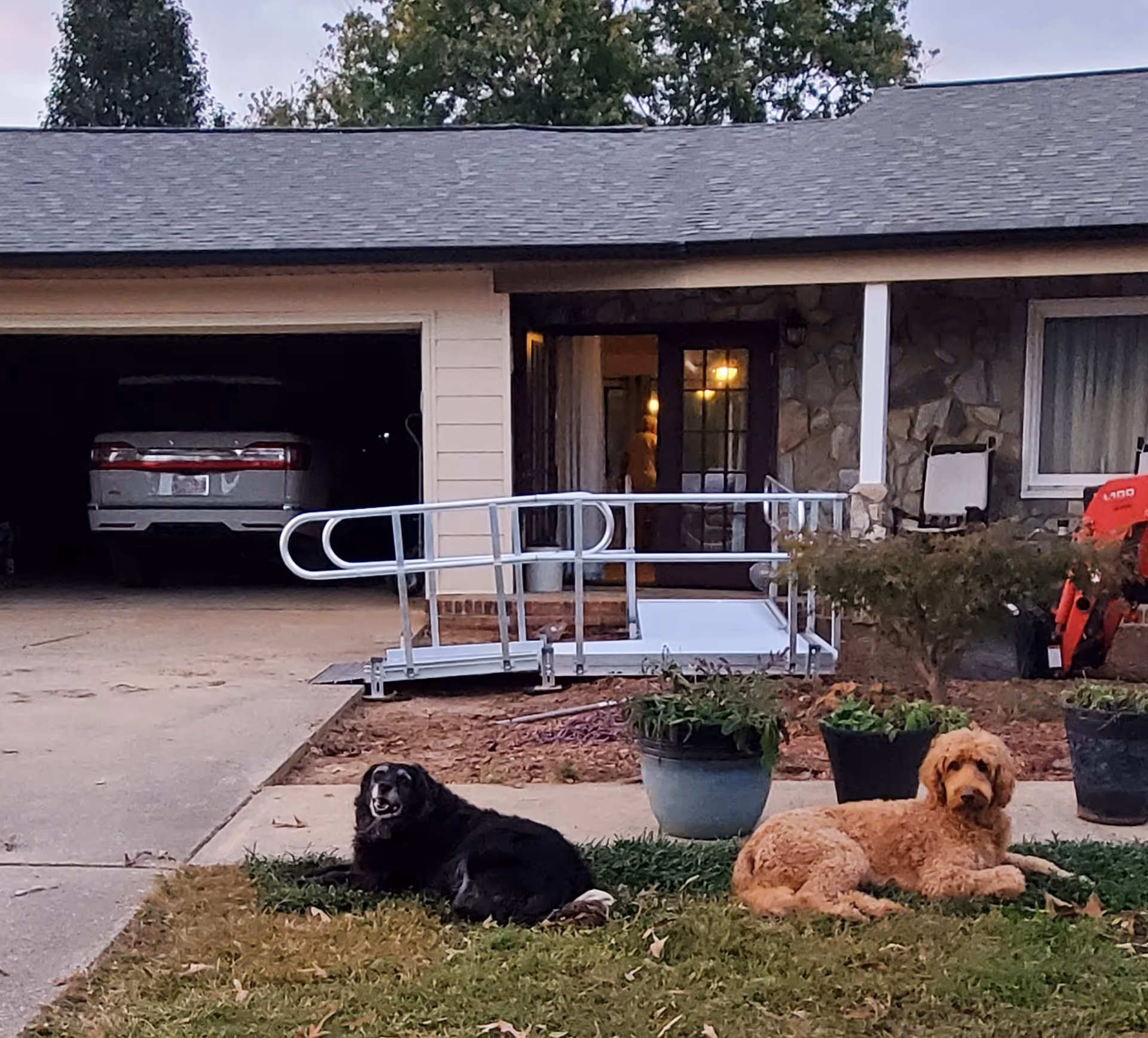 Exterior view of a single-story facility with a ramp and two dogs on the front lawn.