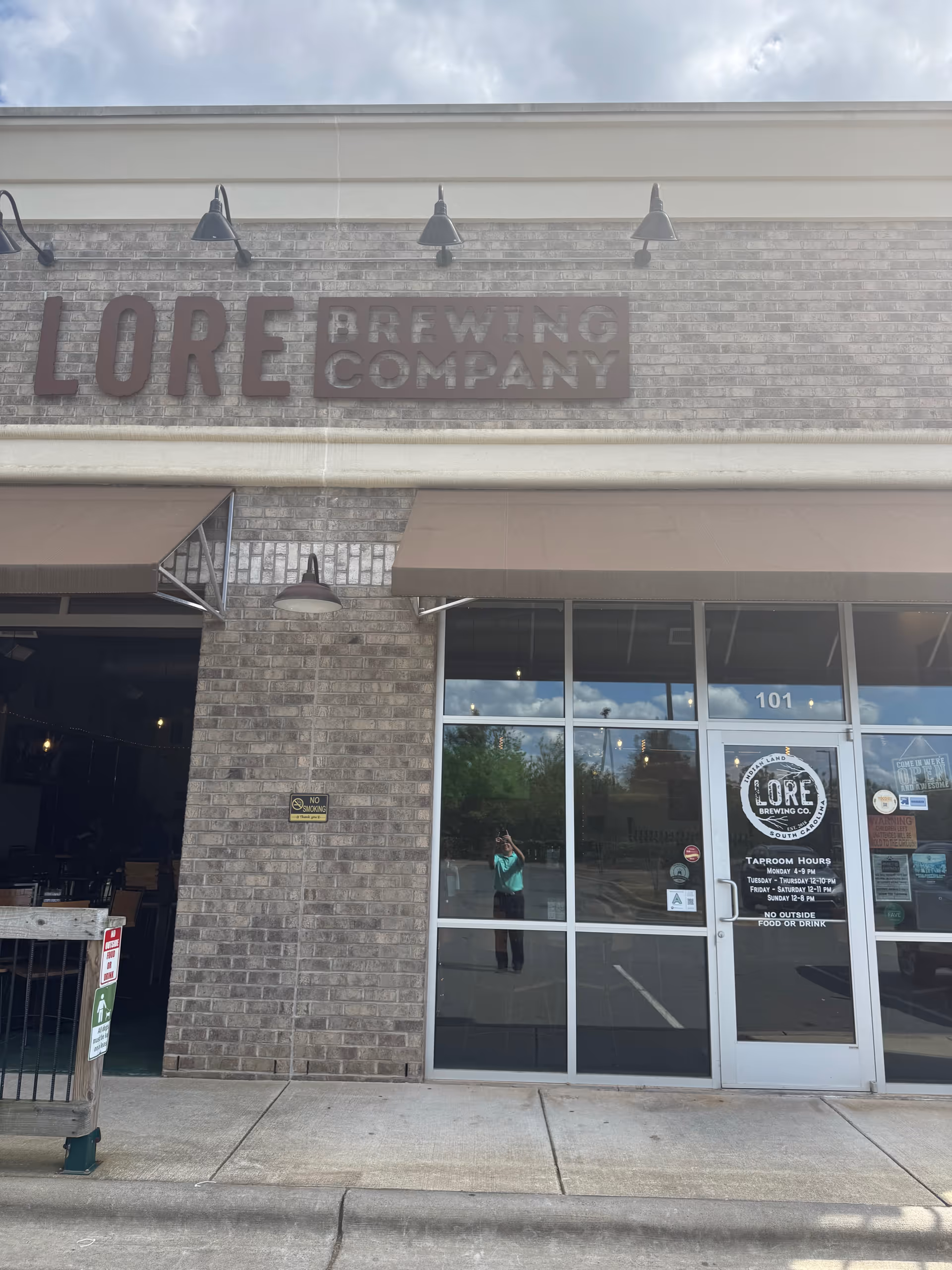 Exterior view of Lore Brewing Company storefront with glass doors and sidewalk.