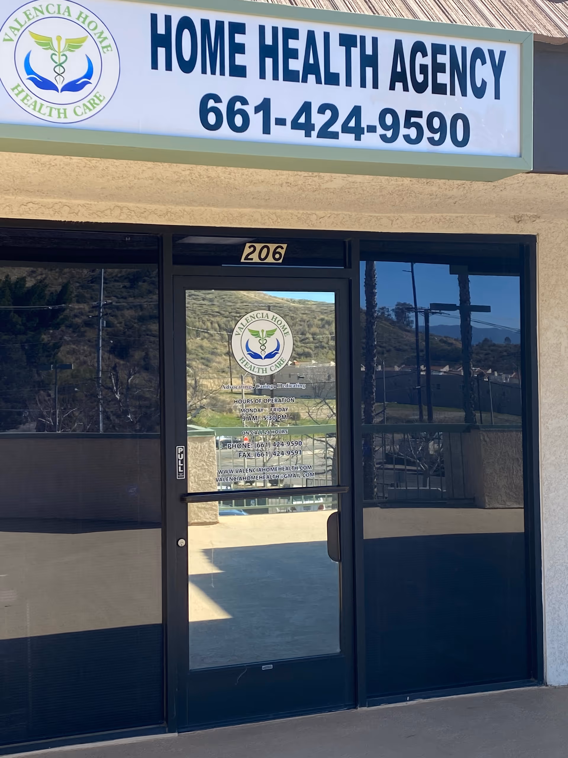 Exterior of Valencia Home Health Care with a glass door entrance and sign.