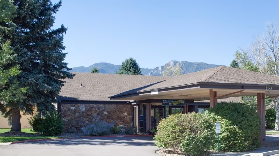Exterior view of Mountain View Post Acute facility with a covered entrance and mountains in background.