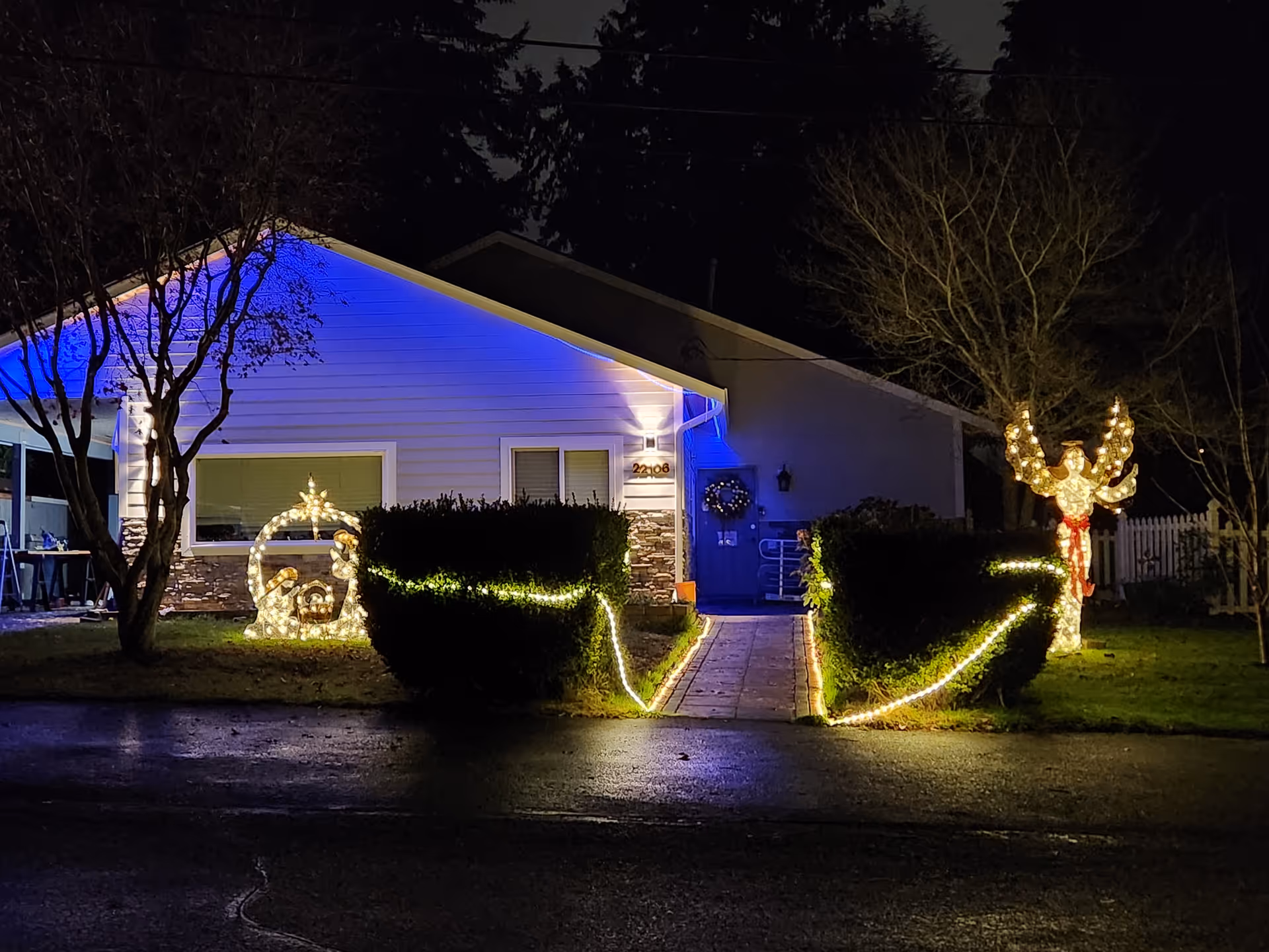 Night exterior of a single-story care facility with blue lighting and festive decorations.