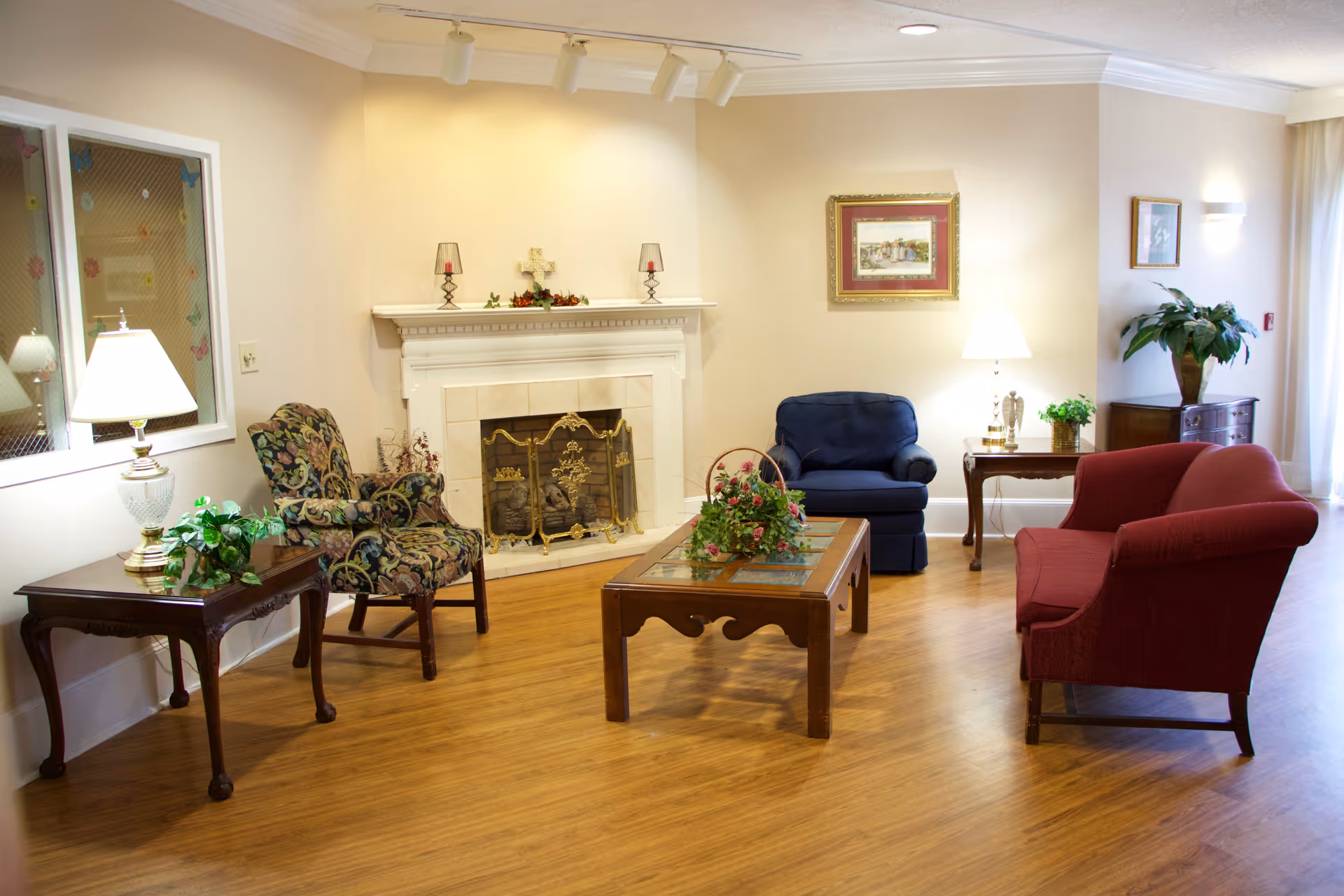 Cozy living room common area with sofa, chairs, fireplace, and wooden coffee table.