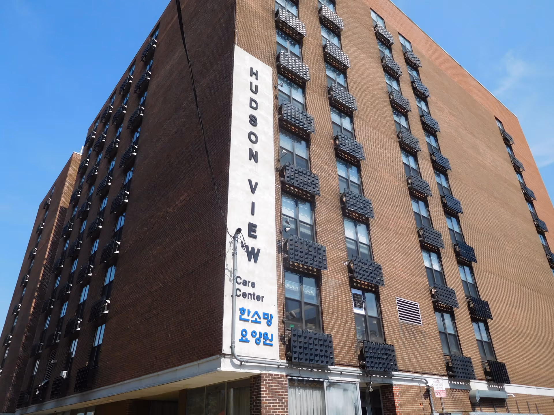 Tall brick building with a vertical Hudson View sign and care center lettering on the front.