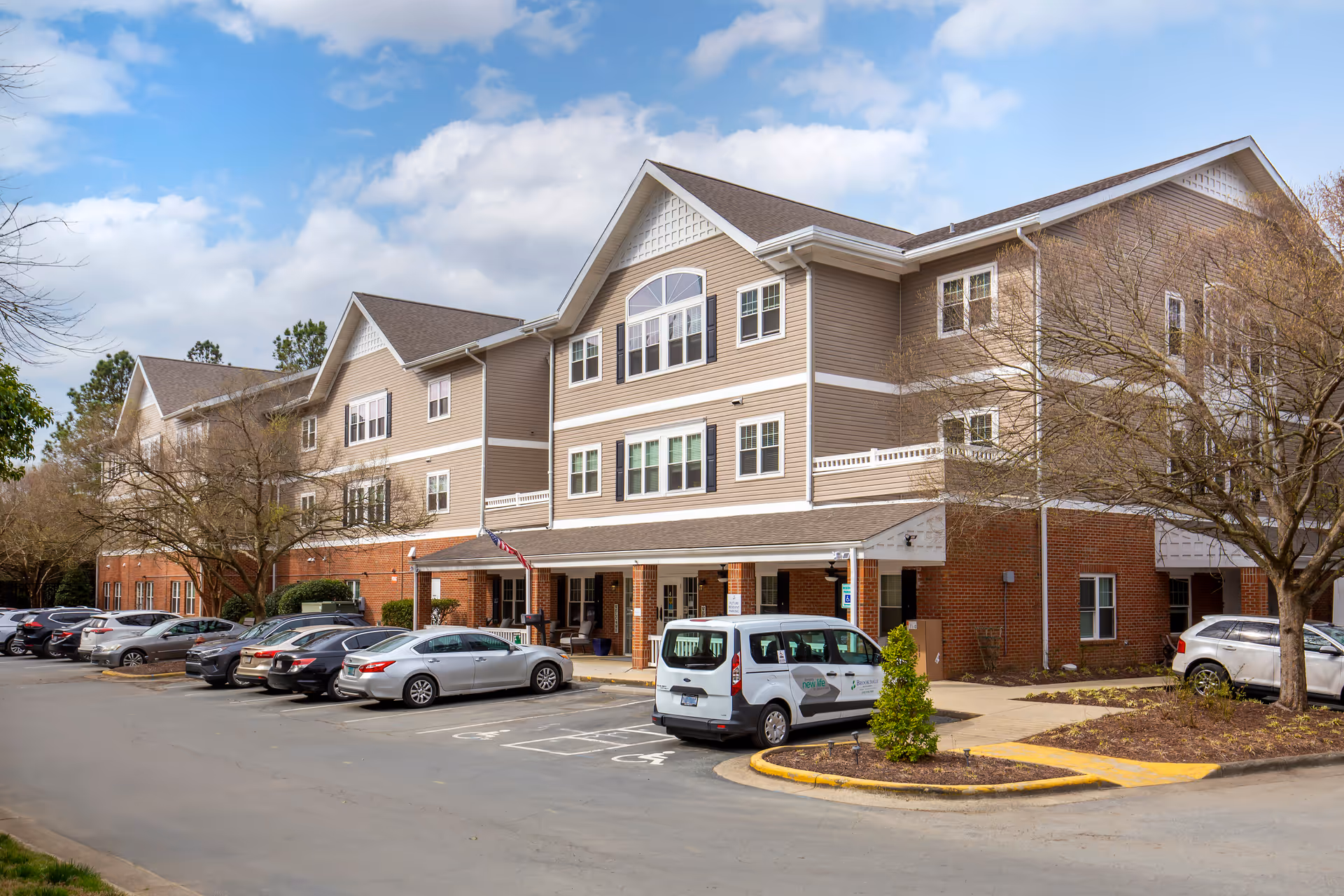 Exterior of Brookdale Meadowmont senior living facility with parked cars in front.