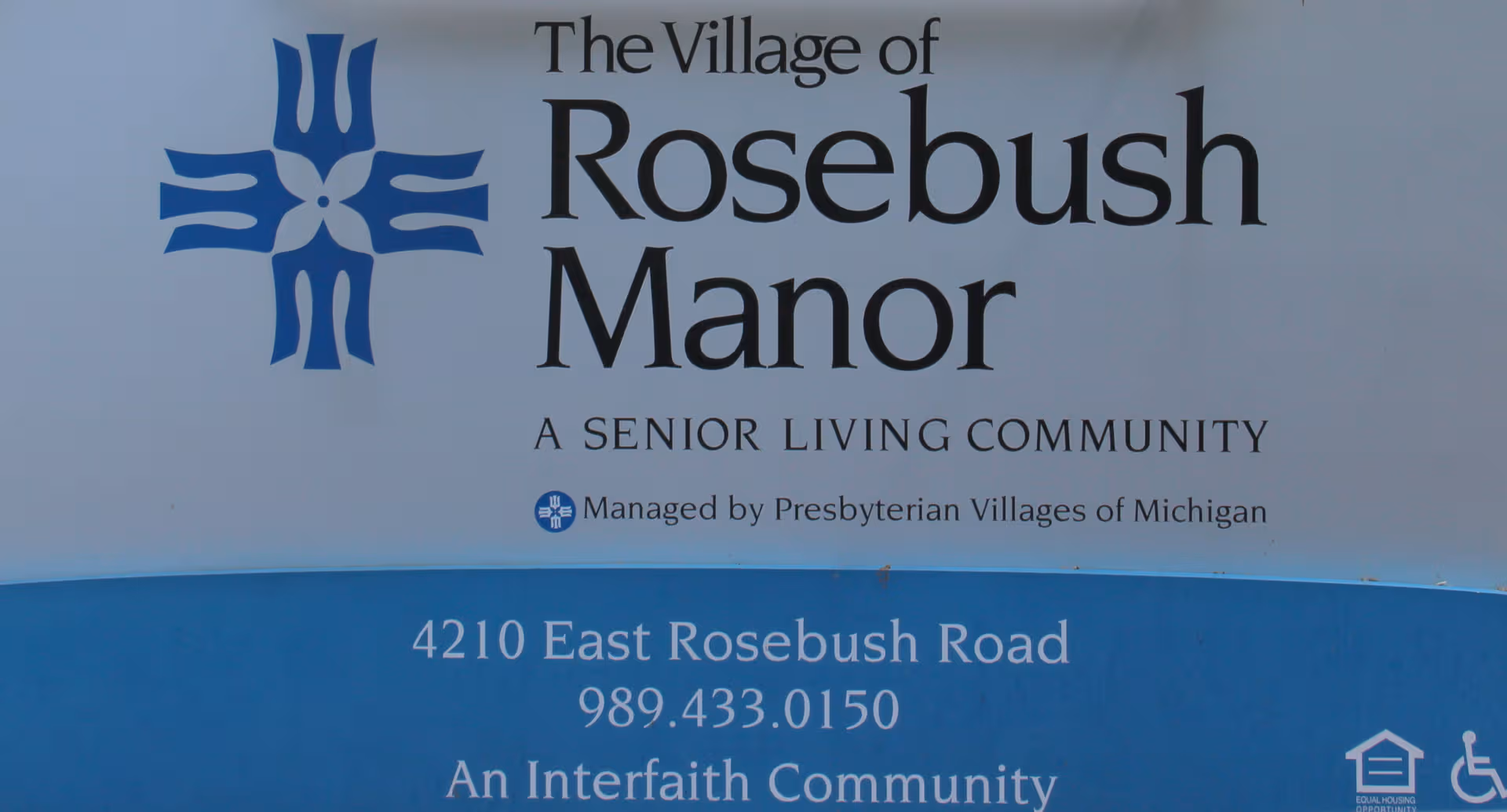 Front sign for The Village of Rosebush Manor senior living community.