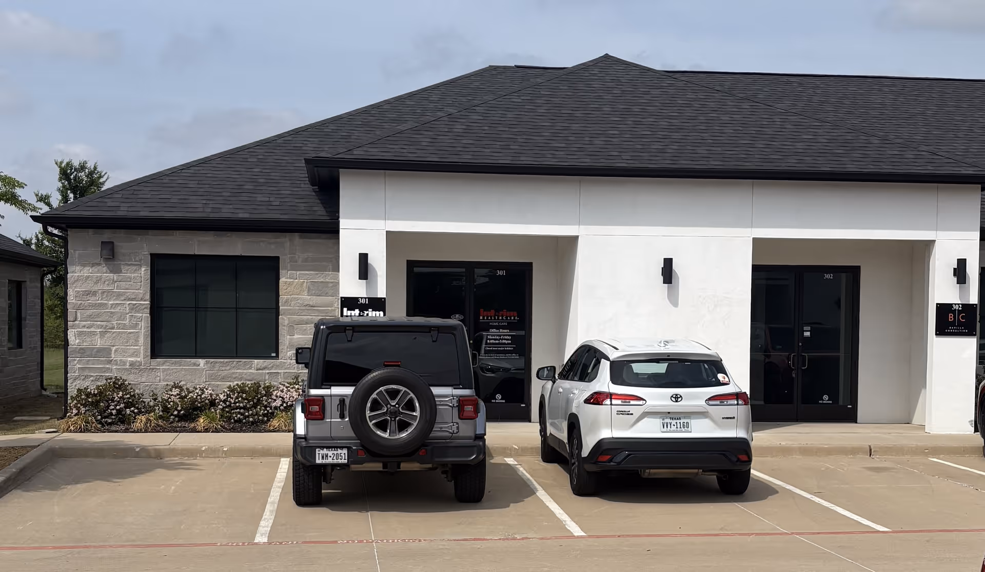 Exterior front view of Interim Home Healthcare building with two parked cars.