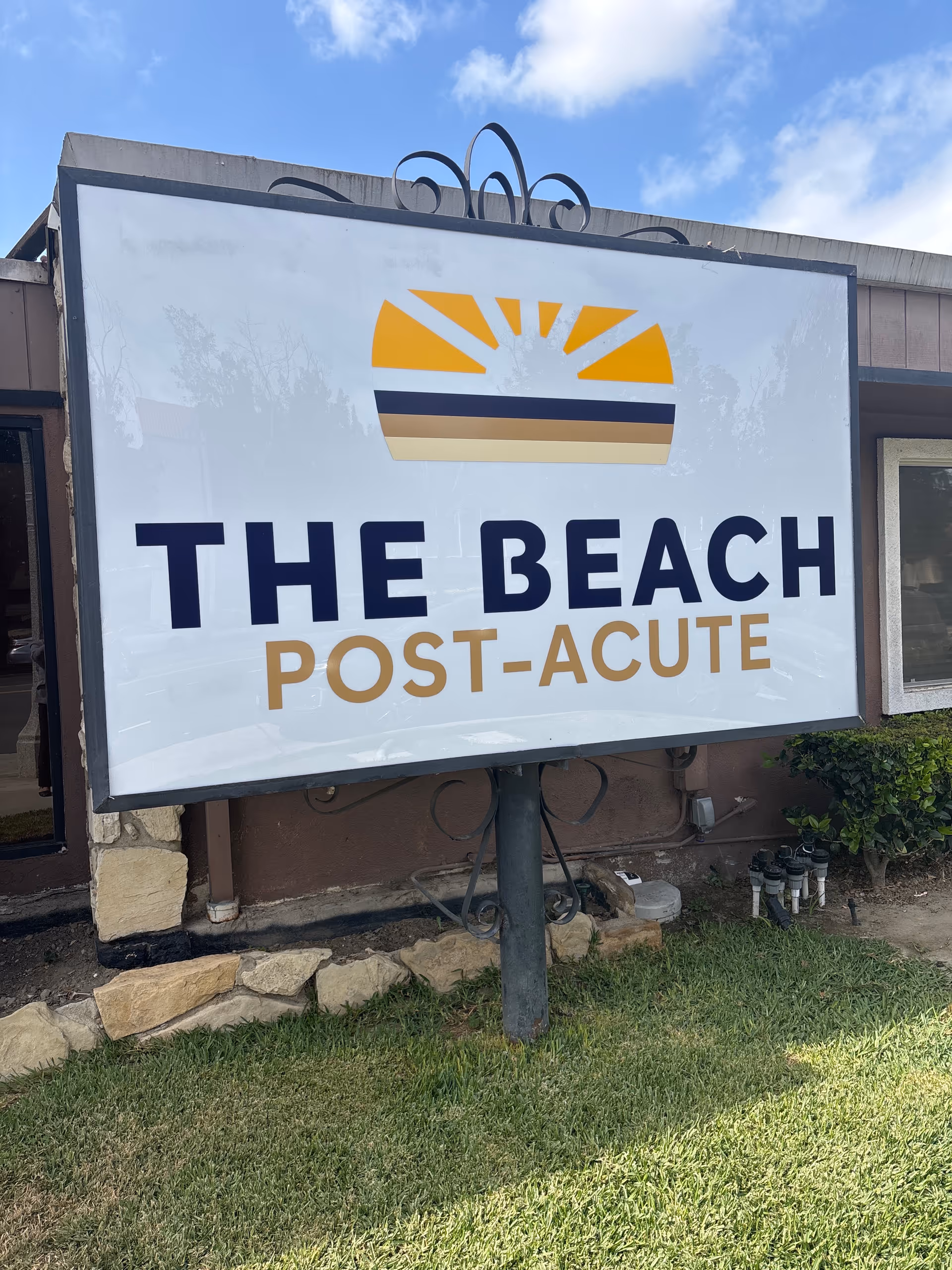 Large sign on a post reads The Beach Post-Acute in front of a building.