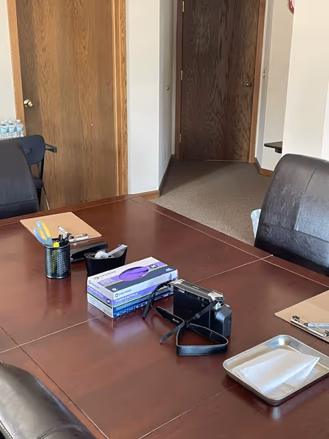 Wood conference table with office supplies in a senior living facility hallway.