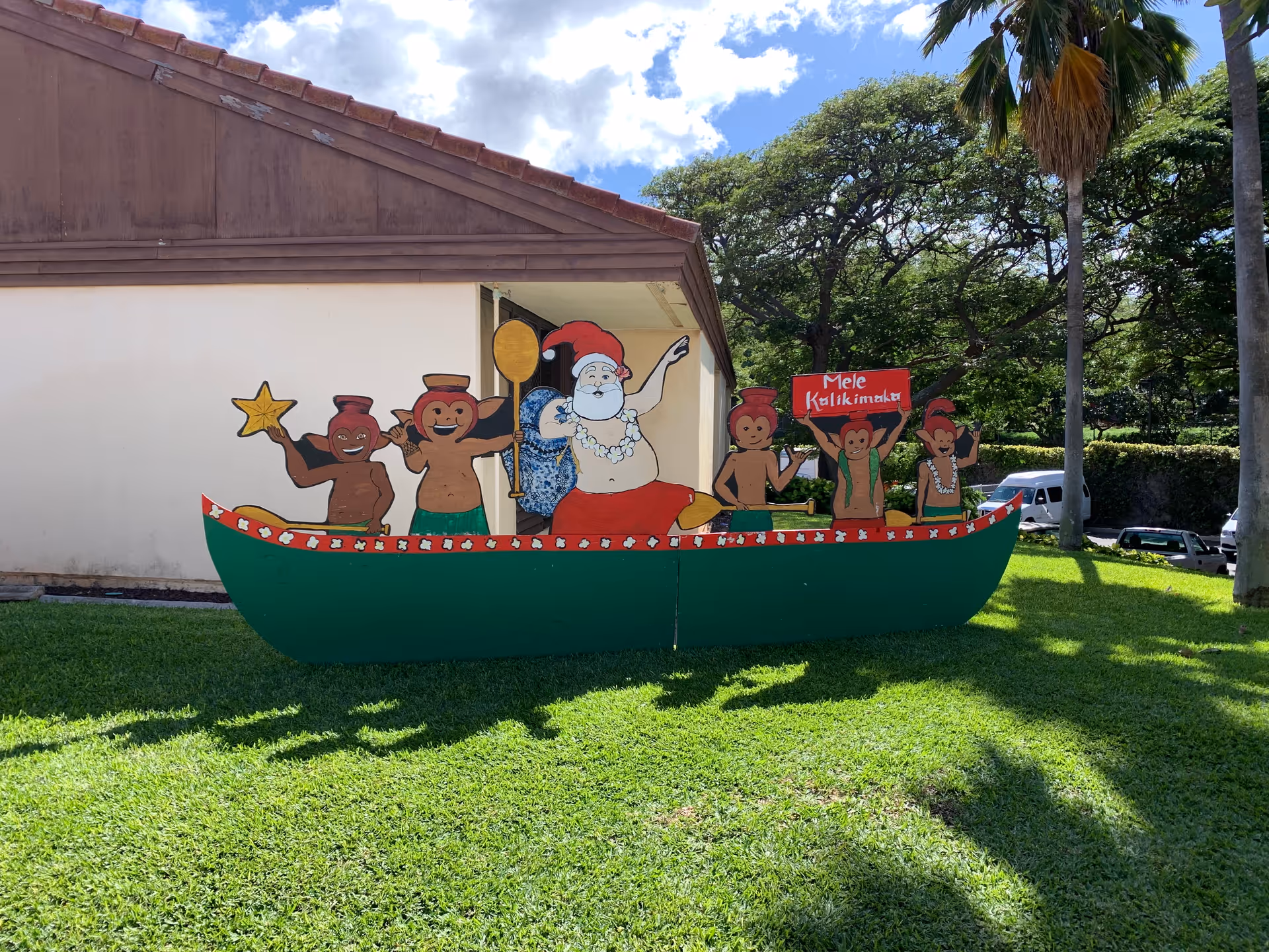 Colorful boat-shaped outdoor sculpture on a lawn in front of Hale Makua Health Services.