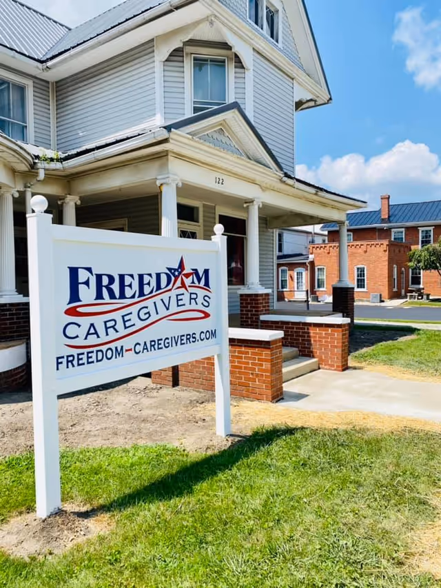 Exterior view of Freedom Caregivers facility with a prominent sign in front.