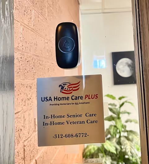 Glass door with USA Home Care PLUS sign and plant visible inside