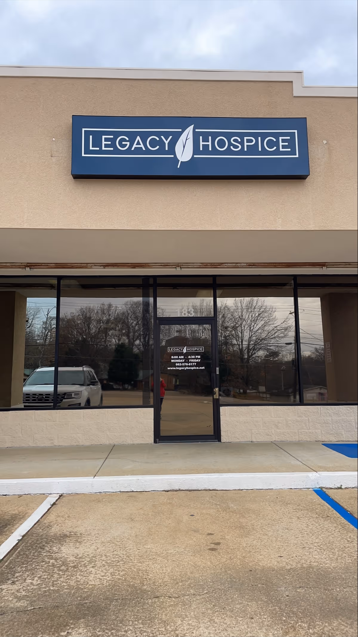 Exterior view of a Legacy Hospice building with a blue sign above the entrance