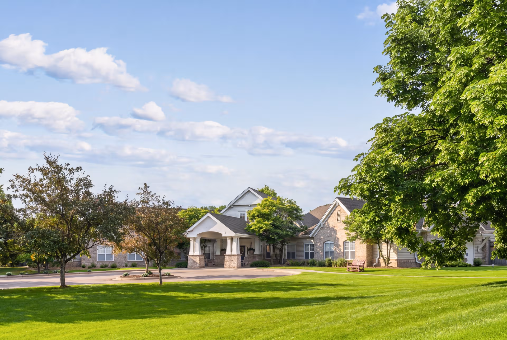 Exterior view of Lakeside Memory Care building with green lawn and trees