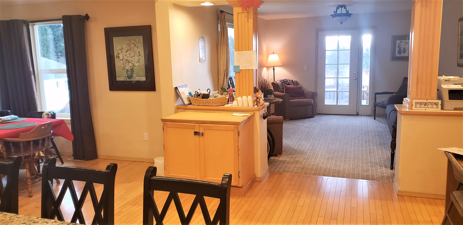 Open, well-lit common area with dining table, counter, and lounge seating.