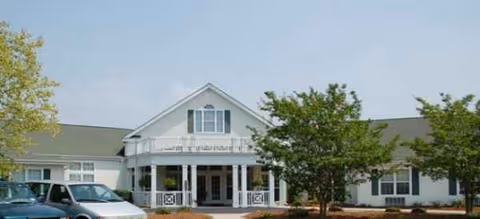Front exterior of Brookdale Dickinson Avenue senior living, showing entrance and parked cars.