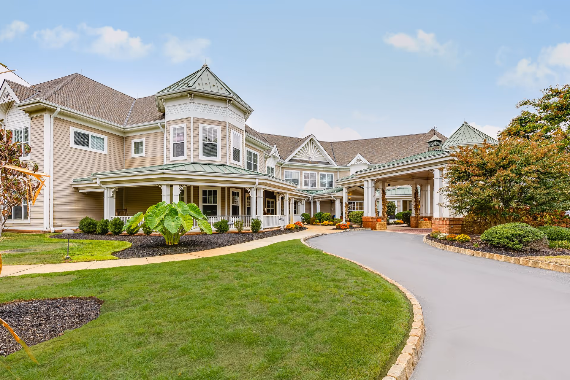 Sunrise of Wall senior living facility exterior with driveway, landscaped lawn, and covered entrance.