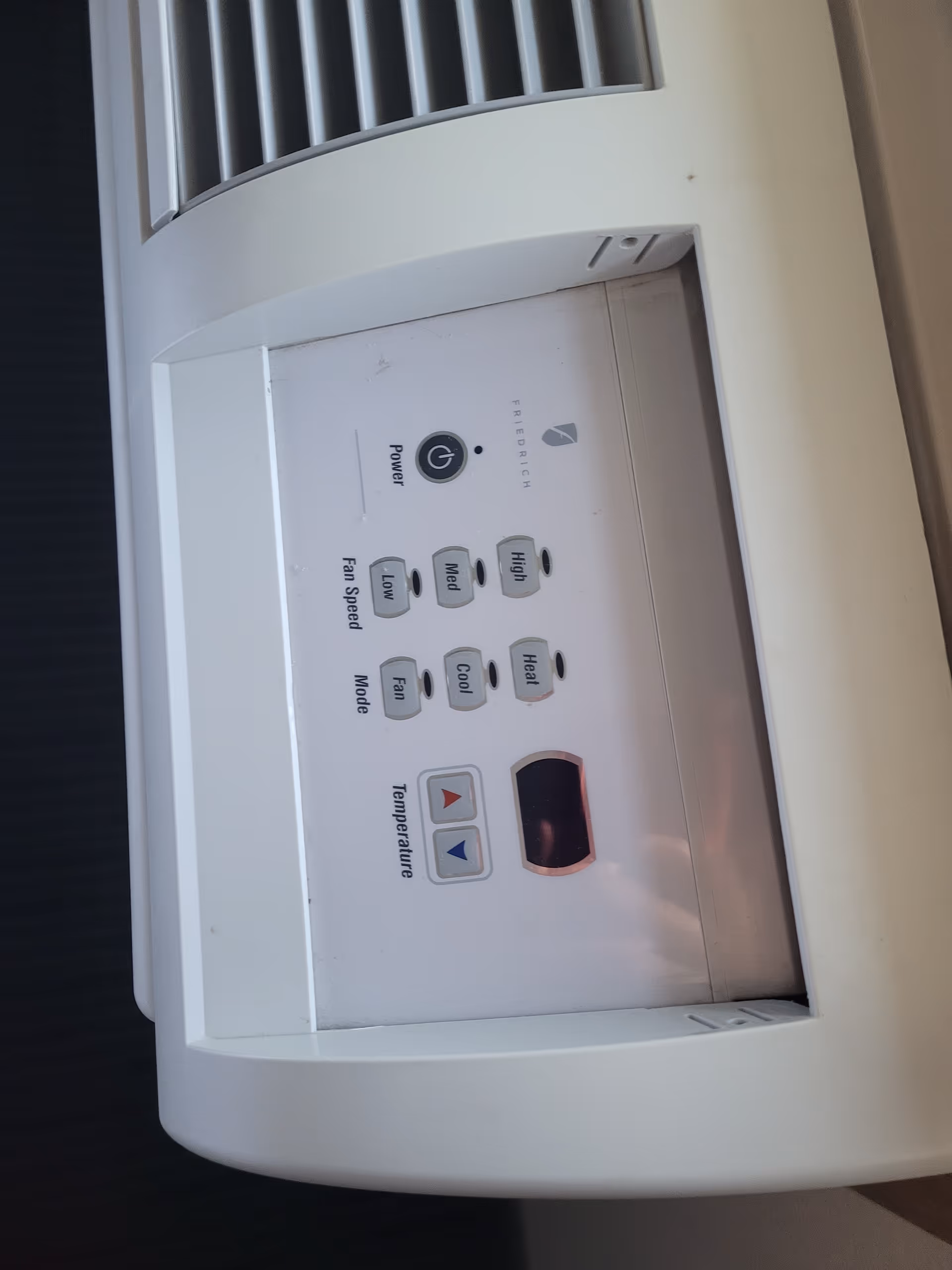 Close-up of a wall thermostat with mode and temperature controls.