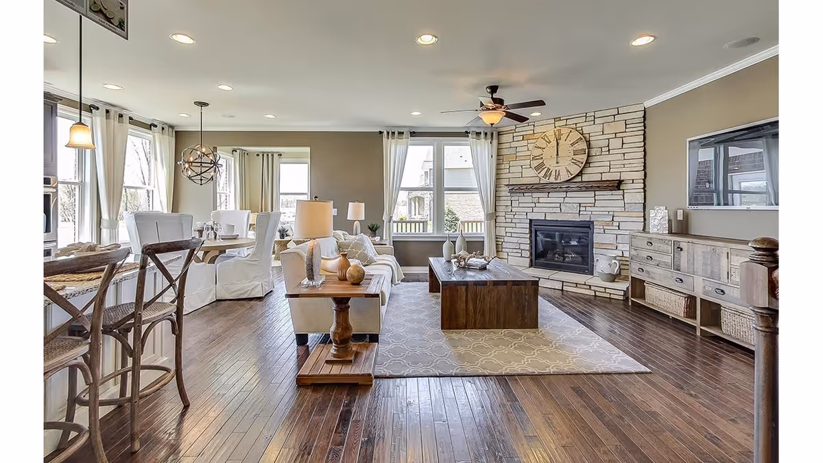 Bridgewater Brownstown living room: spacious, well-lit with fireplace, stone wall, and ample seating.