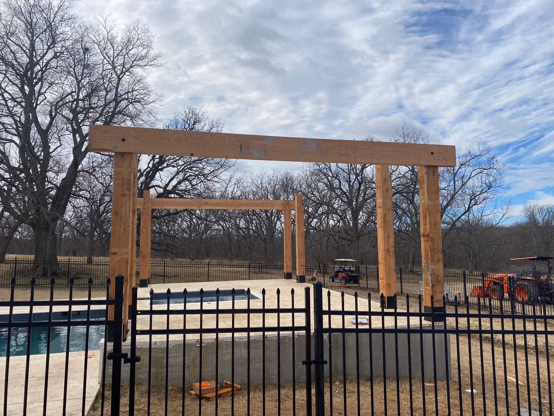 Wooden frame structures over a fenced pool area at Vibrant Life Oklahoma.