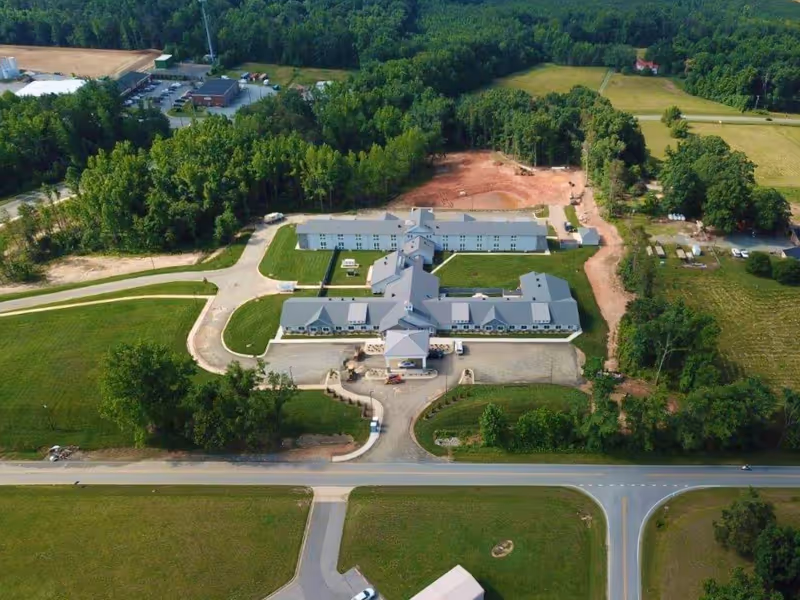 Aerial view of The Landings of Rockingham campus with white buildings and surrounding greenery.
