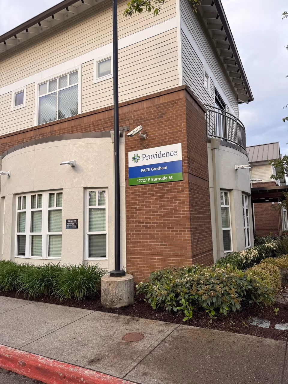 Exterior view of Providence Elderplace Gresham building with sign and landscaping